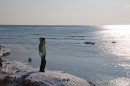 Девушка что-то высматривает в море